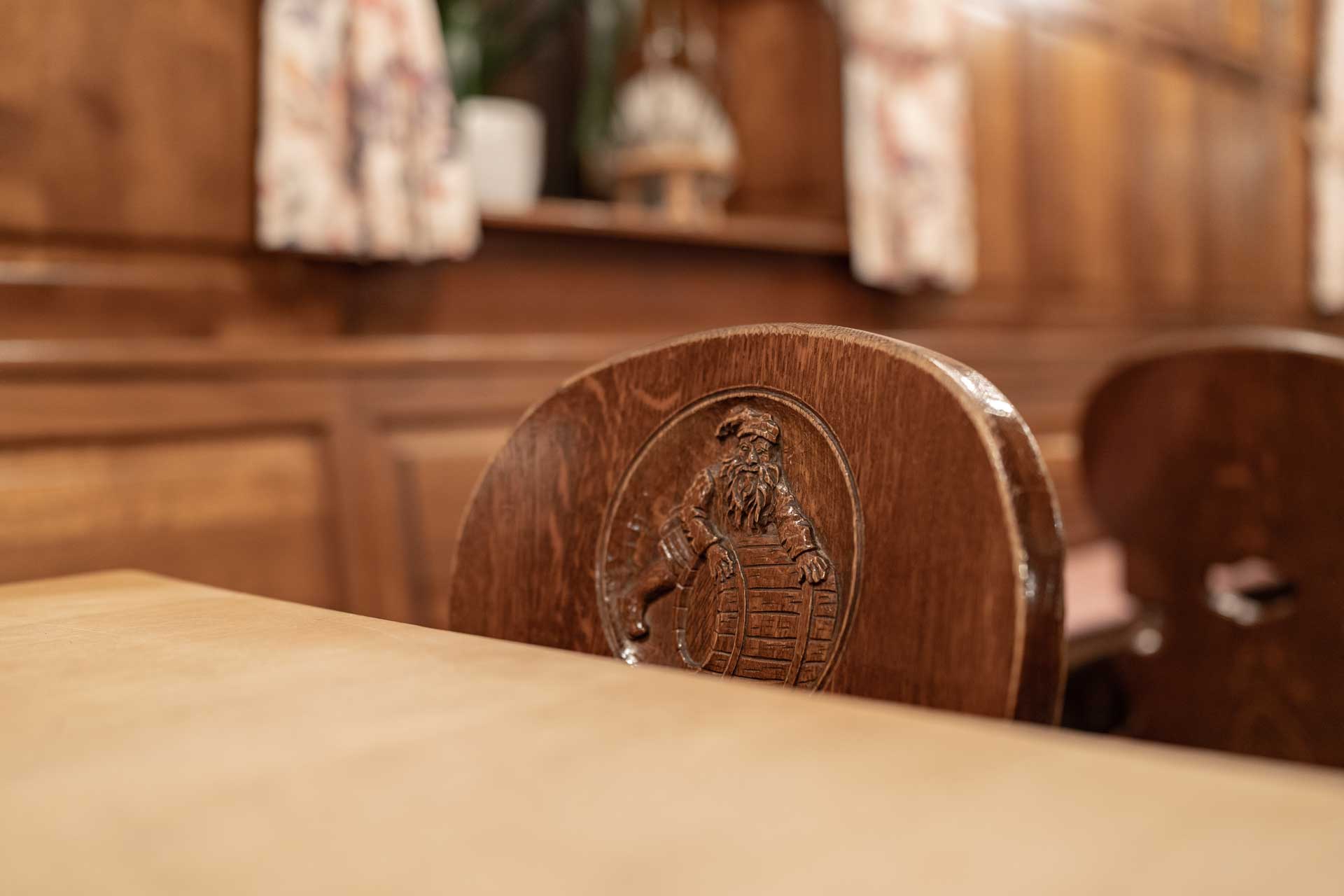 Fässla Bamberg – Unser Gasthof Lehne eines Holzstuhls mit dem Fässla Logo in der Bamberger Brauereigaststätte